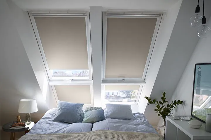 Schlafzimmer mit Verdunkelungsrollos an zwei VELUX Dachfenstern